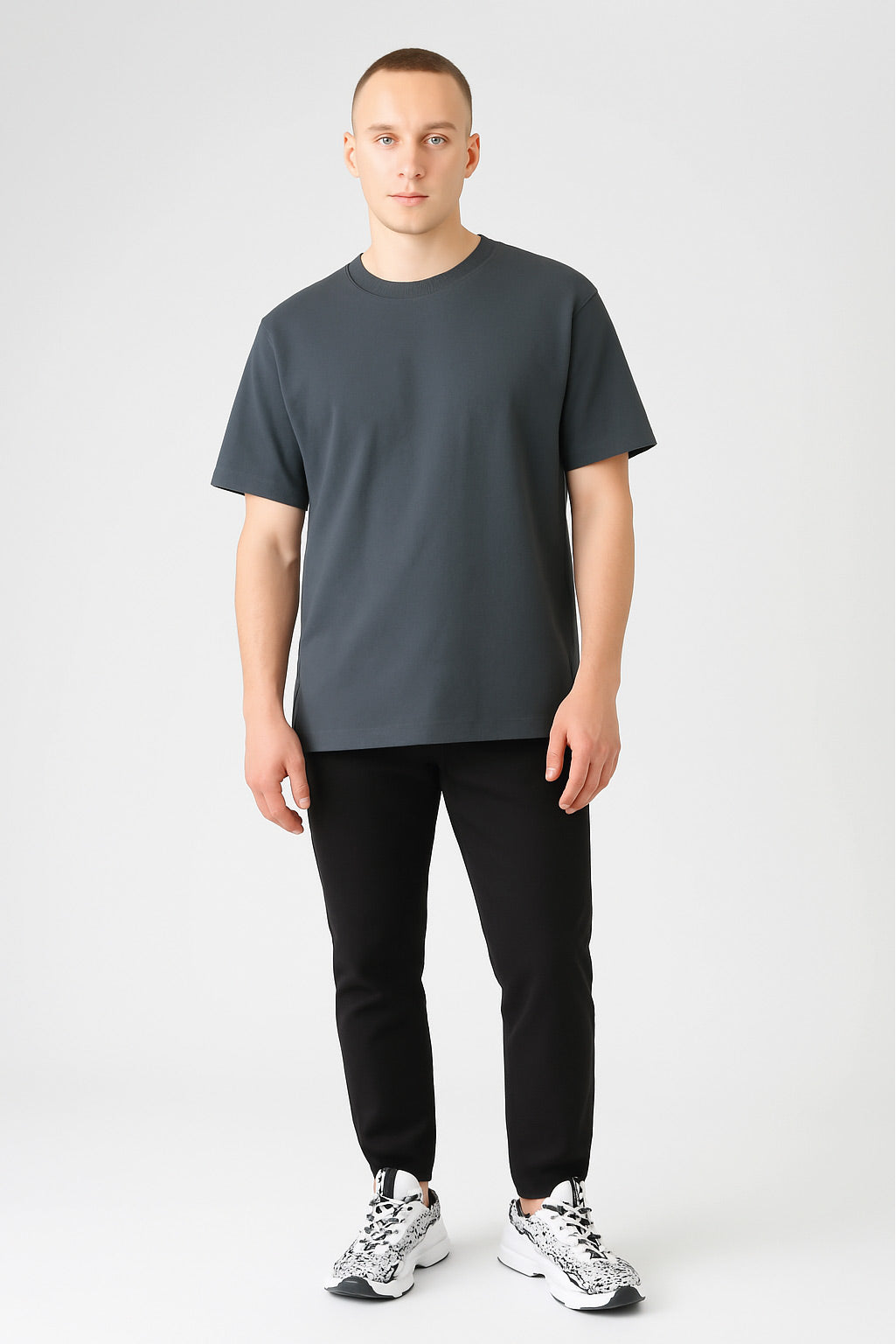 T-Shirt im BoxFit Schnitt aus 220 GSM Bio-Baumwolle in Anthrazit. Mann trägt minimalistisches, nachhaltiges T-Shirt mit lockerer Passform und Rundhalsausschnitt. Perfekt für moderne Casual Outfits und umweltfreundliche Mode.