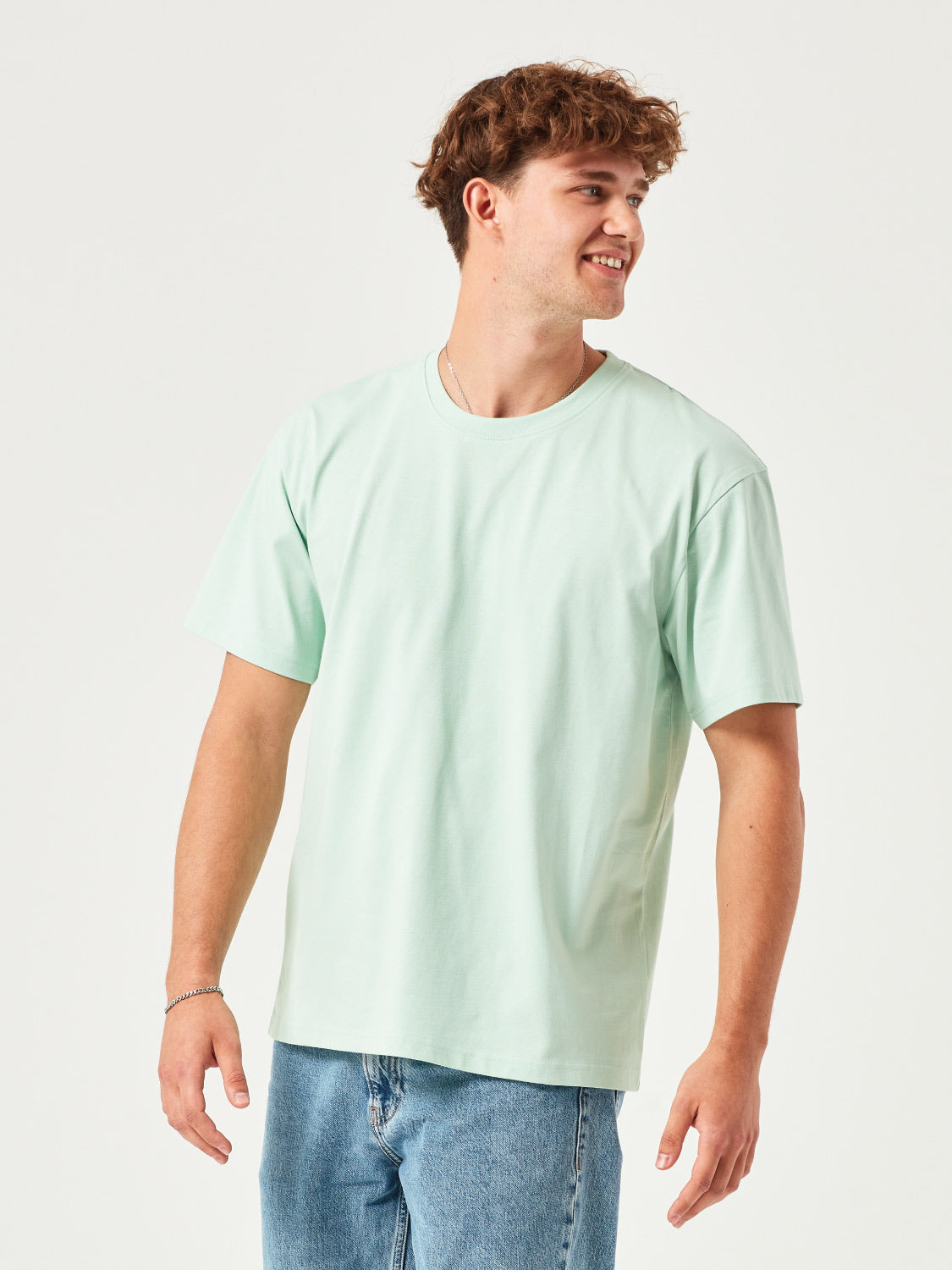 Mann trägt ein mint grünes BoxFit T-Shirt aus 100% Bio-Baumwolle – nachhaltige Herrenmode, lässiger Oversize-Schnitt, umweltfreundlich & bequem