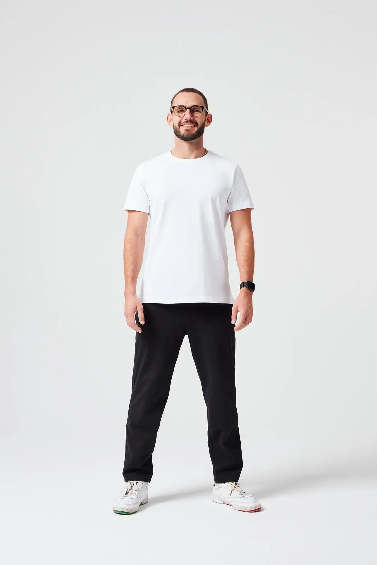 Mann trägt hochwertiges Premium T-Shirt aus 280 GSM Bio-Baumwolle in Weiß mit schwarzer Hose. Nachhaltiges, dickes T-Shirt mit Rundhalsausschnitt, perfekt für moderne Casual Outfits und umweltfreundliche Mode.