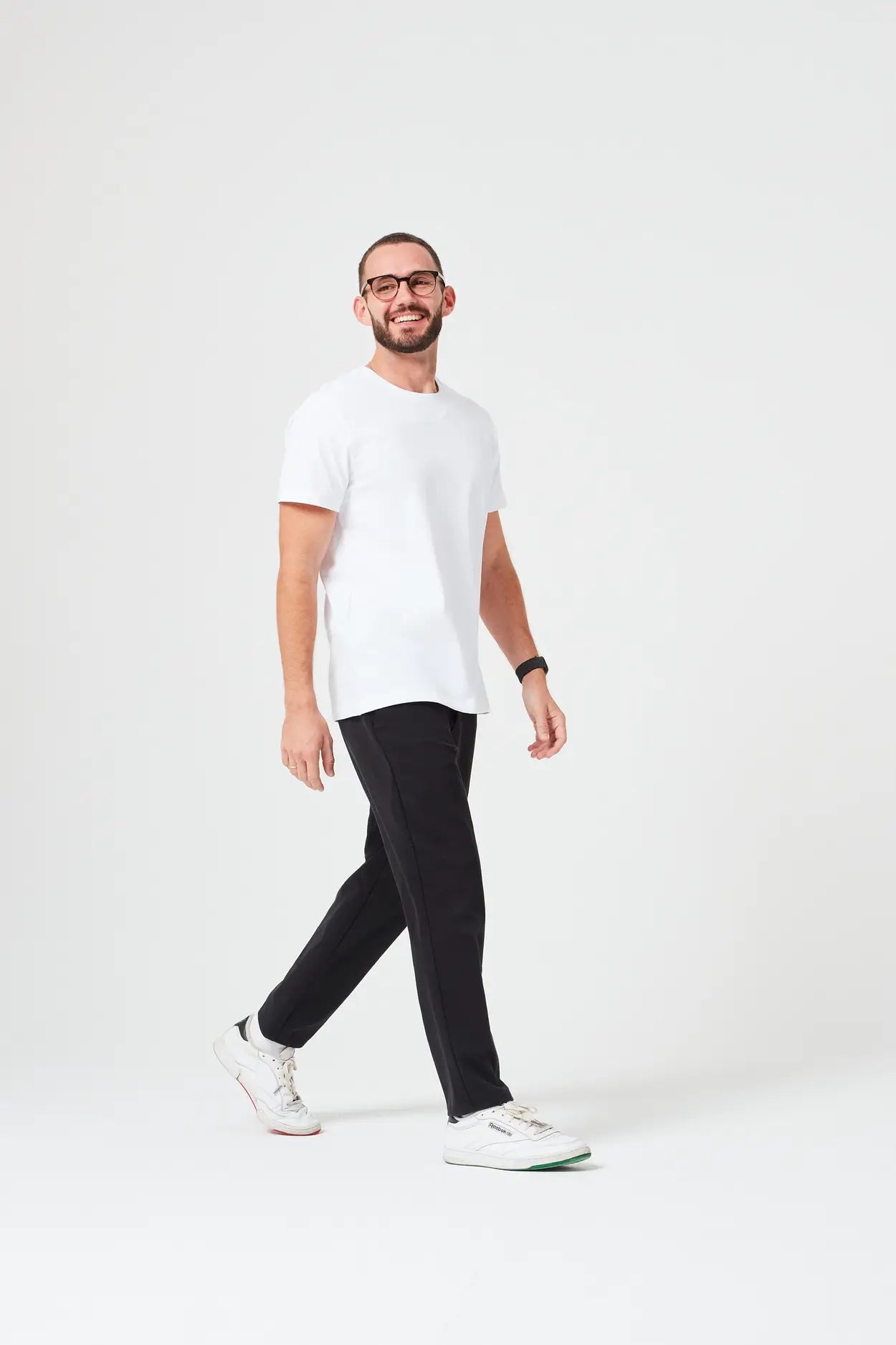 Mann trägt hochwertiges Premium T-Shirt aus 280 GSM Bio-Baumwolle in Weiß mit schwarzer Hose. Nachhaltiges, dickes T-Shirt mit Rundhalsausschnitt, perfekt für moderne Casual Outfits und umweltfreundliche Mode.