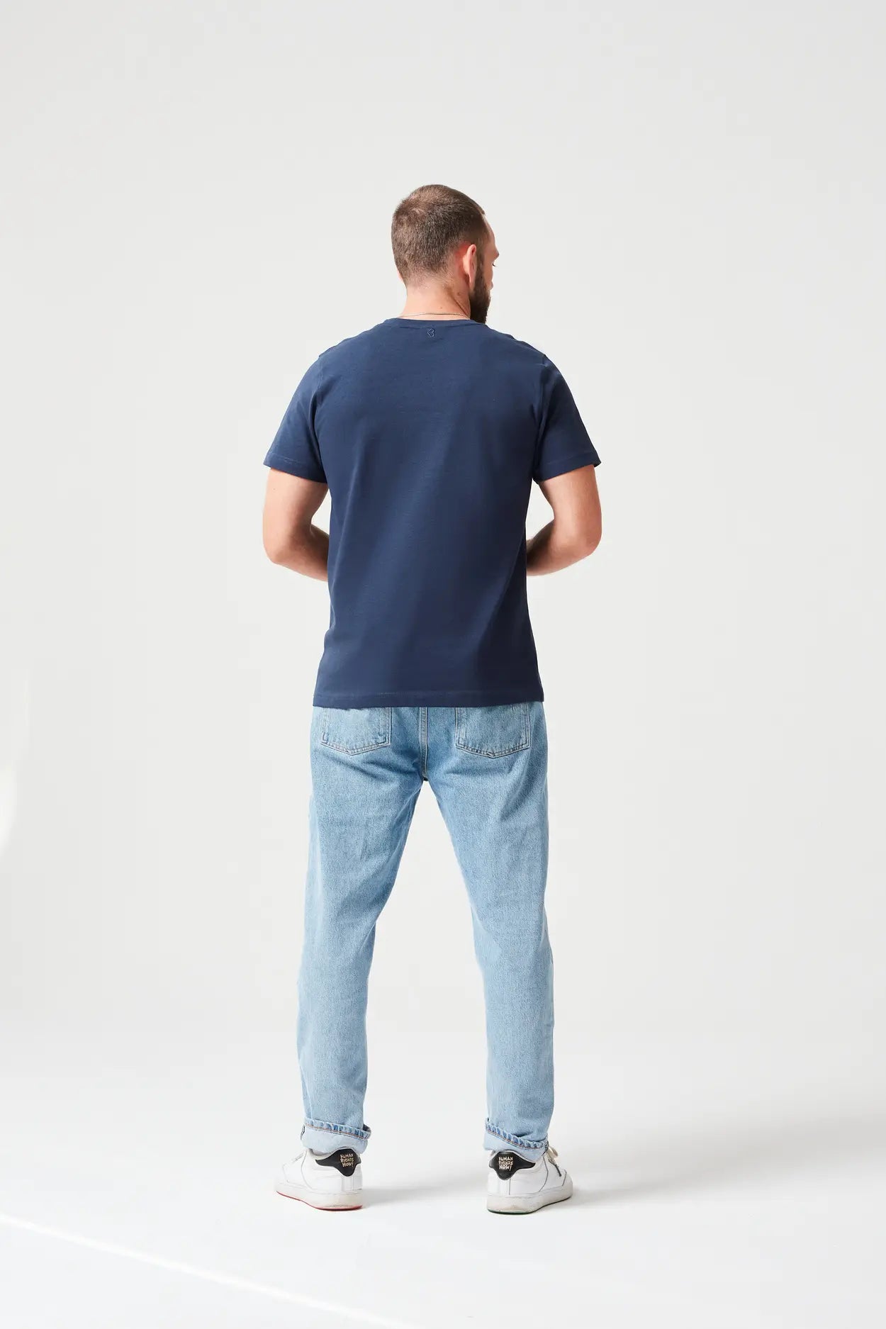 Mann trägt Navy Premium T-Shirt aus 280 GSM Bio-Baumwolle. Hochwertiges, umweltfreundliches Basic-Shirt mit Rundhalsausschnitt, ideal für lässige Alltagsoutfits.