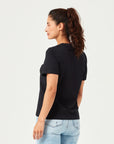 Frau trägt ein minimalistisches schwarzes Damen T-Shirt aus nachhaltiger Bio-Baumwolle. Komfortables Basic-Shirt mit Rundhalsausschnitt, perfekt kombiniert mit hellblauer Jeans. Ideal für Freizeit, Casual Outfits und moderne Streetwear.