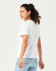 Weißes Damen T-Shirt aus hochwertiger Bio-Baumwolle, seitlich getragen von Frau mit hellblauer Jeans. Komfortables Rundhals-Shirt mit kurzen Ärmeln. Perfektes Basic für moderne Casual Styles und nachhaltige Damenmode.