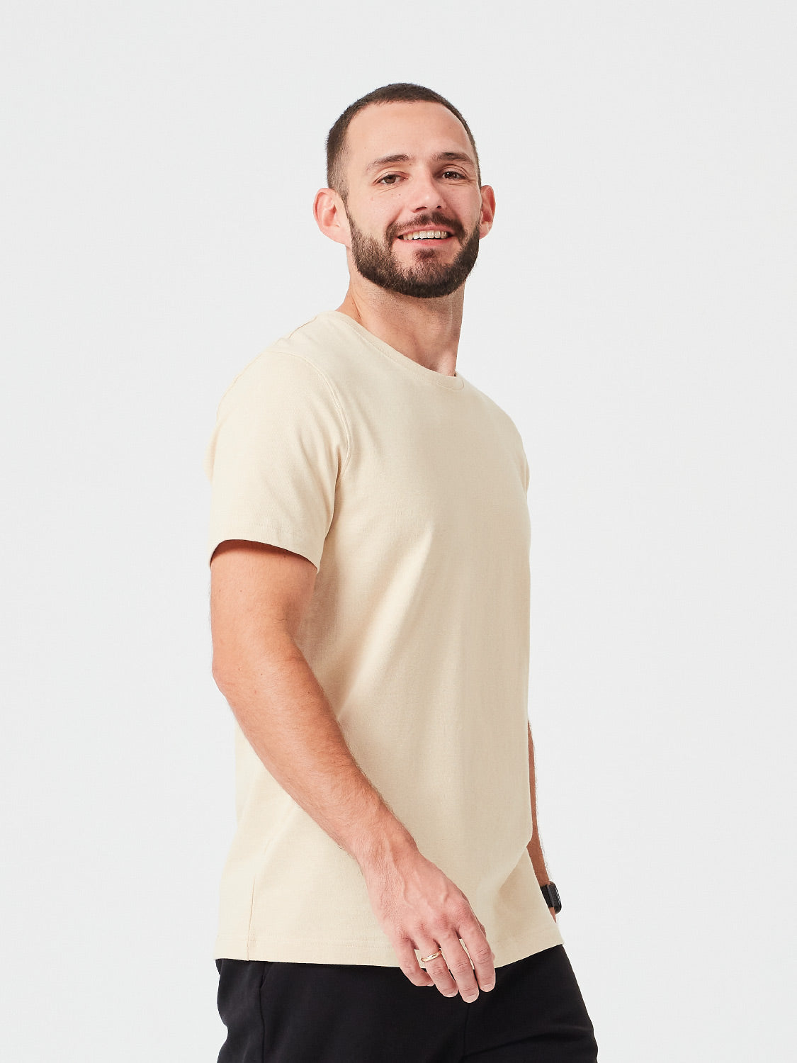 Seitenansicht eines Mannes der ein Premium TShirt in der Farbe Sand aus Bio-Baumwolle trägt - nachhaltige Mode für einen lässigen Look.