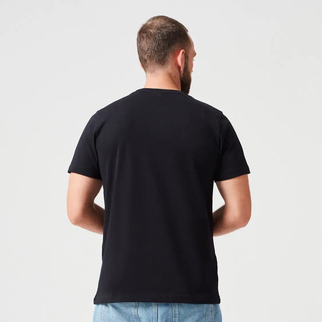 Nachhaltiges Premium T-Shirt aus 280 GSM Bio-Baumwolle in Schwarz, getragen von Mann mit blauer Jeans. Dickes, robustes T-Shirt für stilvolle Casual Looks und umweltbewusste Streetwear.