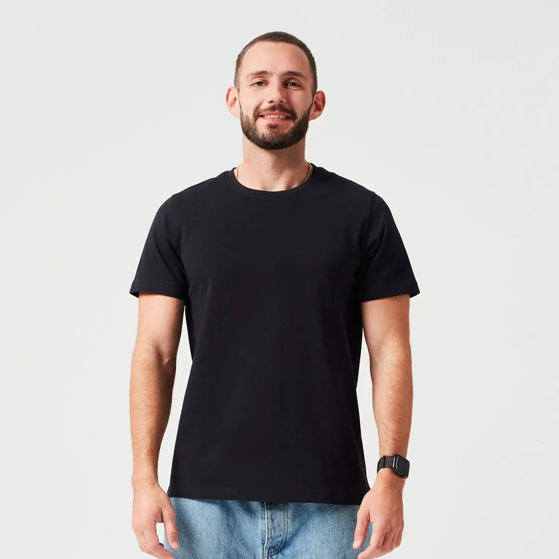 Nachhaltiges Premium T-Shirt aus 280 GSM Bio-Baumwolle in Schwarz, getragen von Mann mit blauer Jeans. Dickes, robustes T-Shirt für stilvolle Casual Looks und umweltbewusste Streetwear.