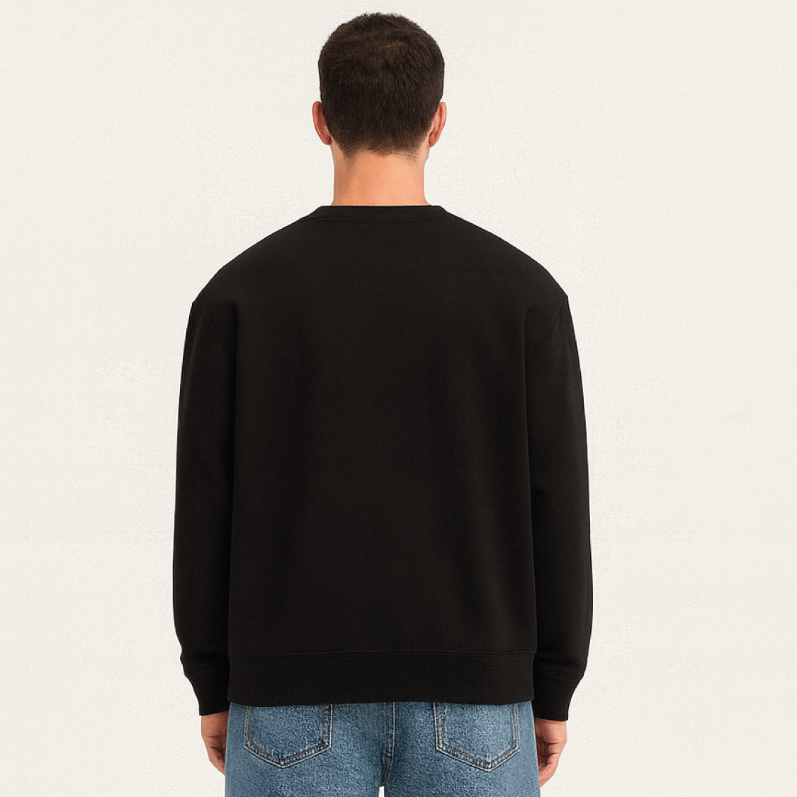 Rückansicht von Sweatshirt in Schwarz – klassischer Oversized-Pullover kombiniert mit blauer Jeans