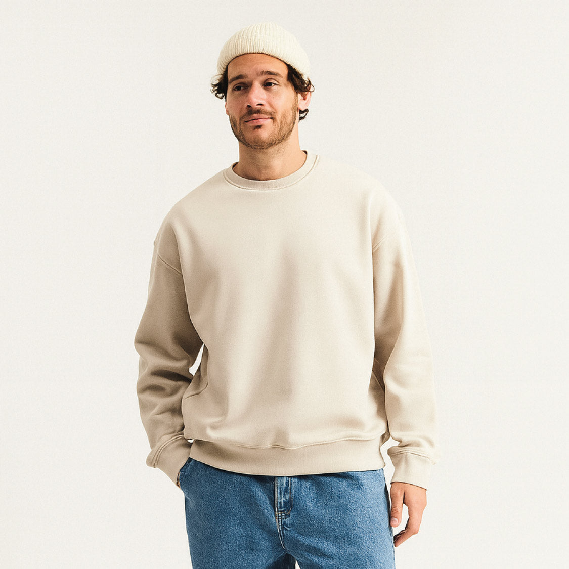 Sweatshirt für Herren in Beige – lässiges Oversized-Design, kombiniert mit blauer Jeans und weißen Sneakern, ideal für modernen Streetwear-Look im Alltag.