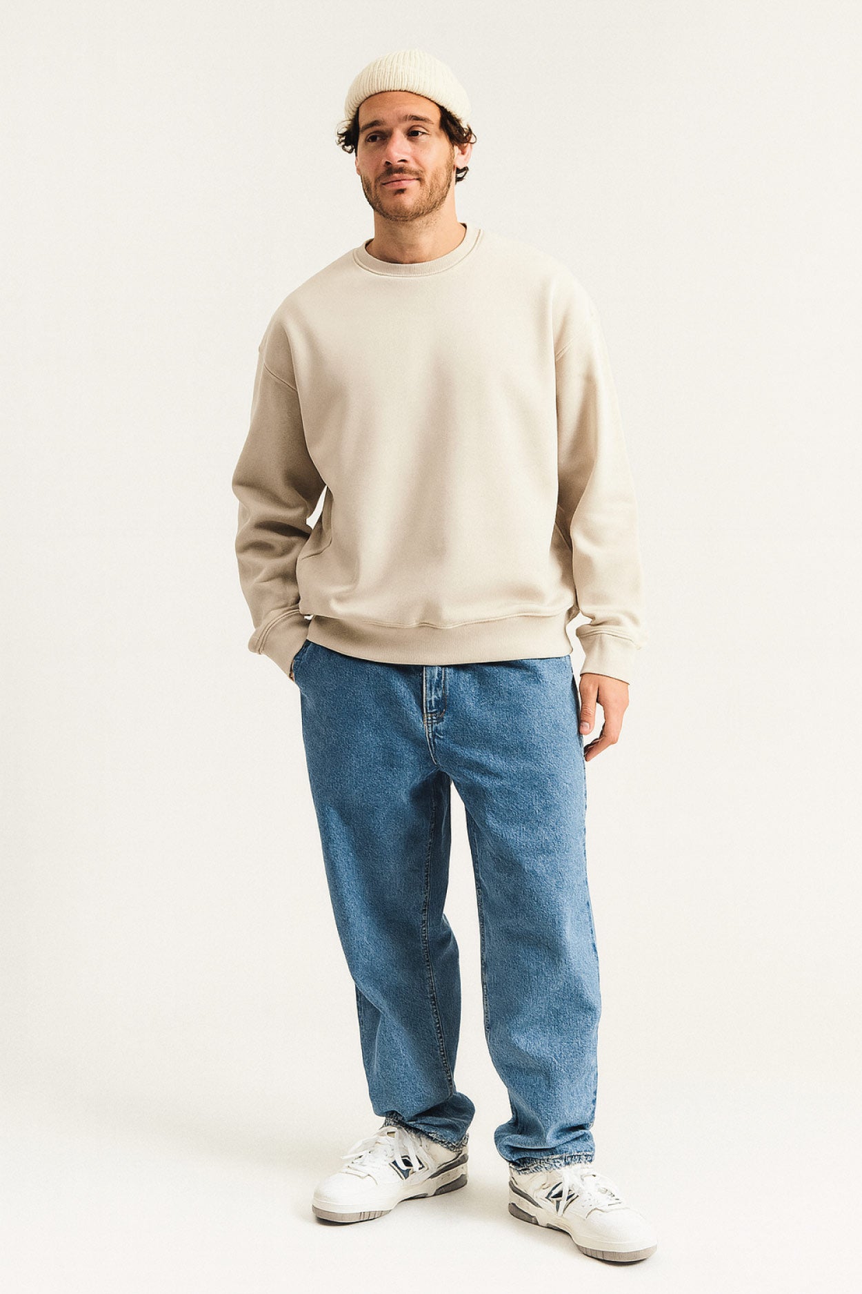 Sweatshirt für Herren in Beige – lässiges Oversized-Design, kombiniert mit blauer Jeans und weißen Sneakern, ideal für modernen Streetwear-Look im Alltag.