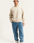 Sweatshirt für Herren in Beige – lässiges Oversized-Design, kombiniert mit blauer Jeans und weißen Sneakern, ideal für modernen Streetwear-Look im Alltag.